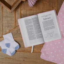 Load image into Gallery viewer, Baby&#39;s First New Testament (KJV) - Lifestyle angled shot with baby items
